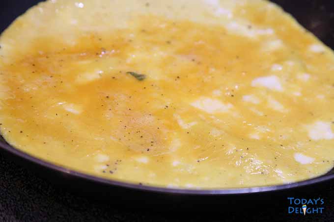 Season and whisk the eggs. Pour and spread beaten eggs in the skillet. Cook until the bottom is firm and runny on top.