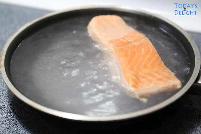 Salmon cooked gently in simmering liquid.