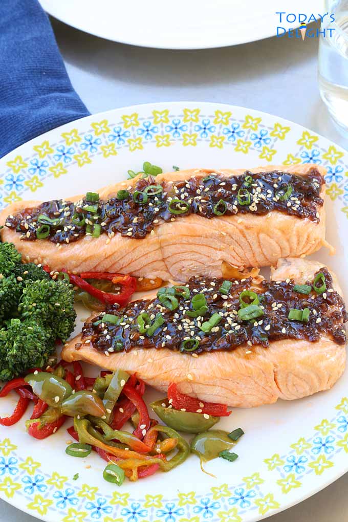 Two servings of poached salmon with teriyaki sauce served with a side of vegetables.