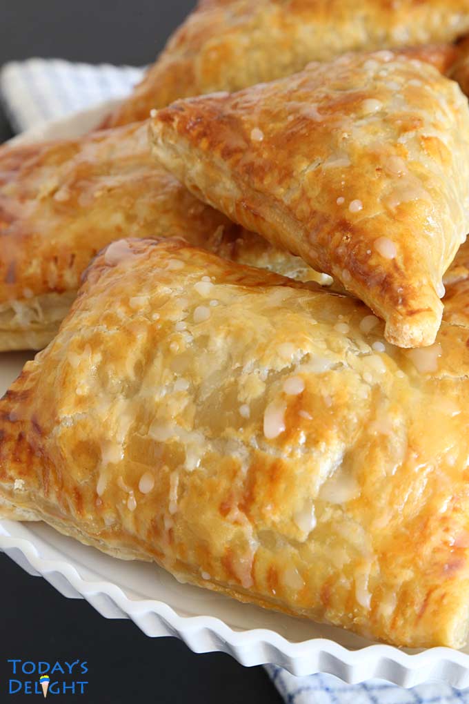 Flaky apple turnovers on cake stand.