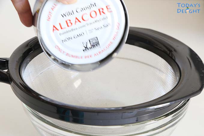 Drain water from canned tuna.