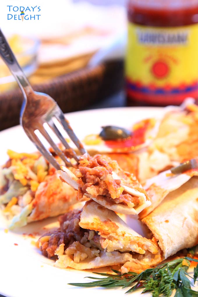 A bite of cheesy refried bean and rice burrito.
