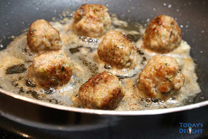 Fried meatballs in skillet.