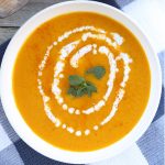 Kabocha Squash Soup with coconut milk and mint leaves at the center.
