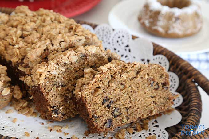 Delicious sliced zucchini bread on a wooden tray with liner.