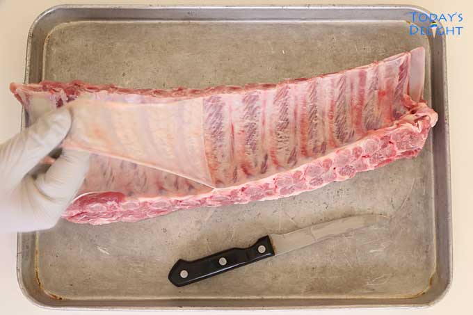Removing membrane at the underside of baby back ribs.
