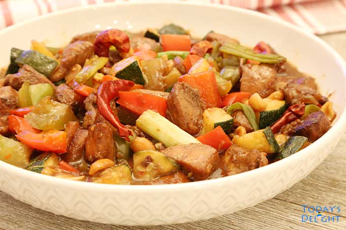 Spicy Kung Pao Chicken with vegetables in a serving bowl.