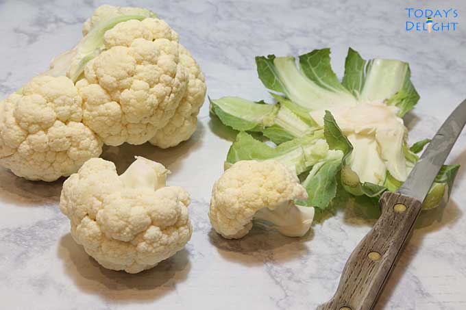 Removing leaves from whole cauliflower.