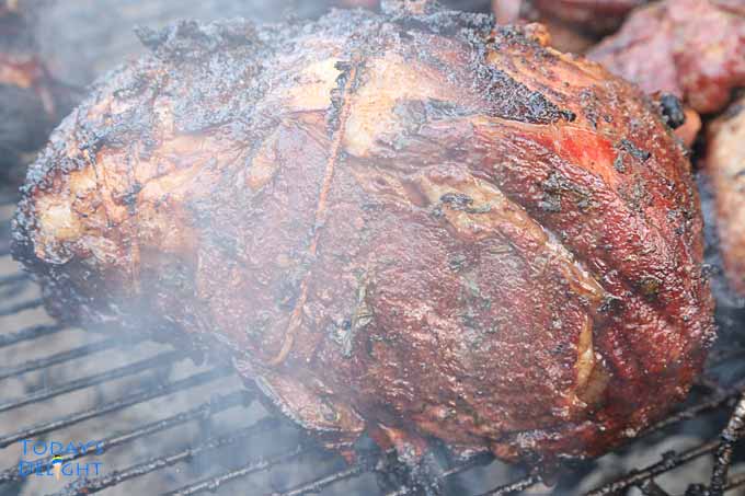 Searing grilled prime rib roast under charcoal.