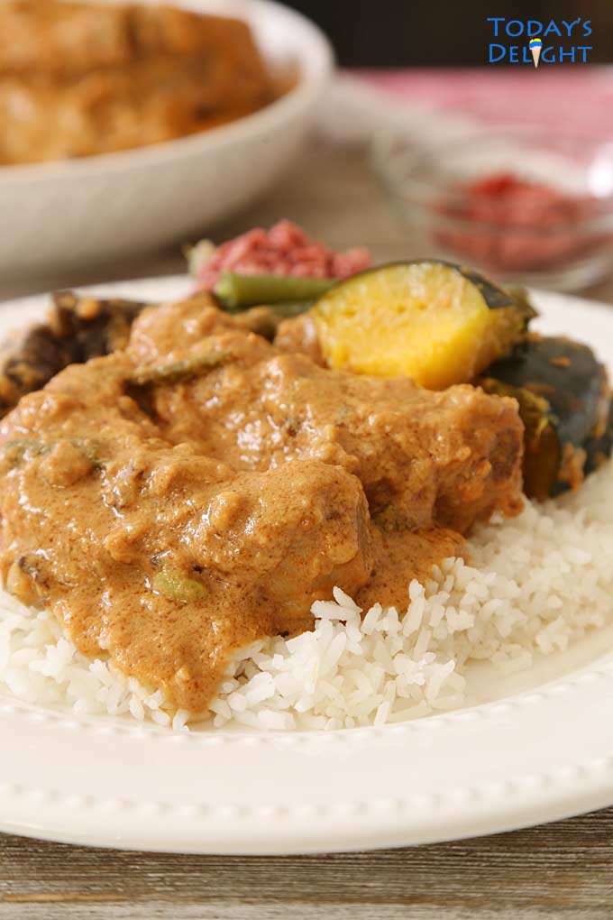 Kare-Kare with coconut milk (gata) is made of ribs and vegetables like squash, green beans, eggplant in peanut sauce and coconut milk on a plate with white rice. A side of shrimp paste is served with this dish. More kare-kare on a serving platter.