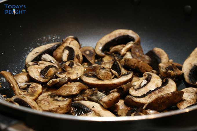 Sauteing sliced baby bella mushrooms.