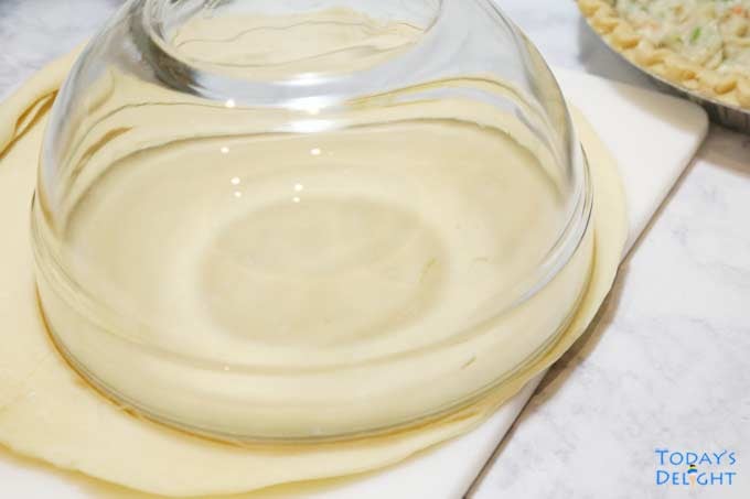 Measuring top pie crust with bowl.
