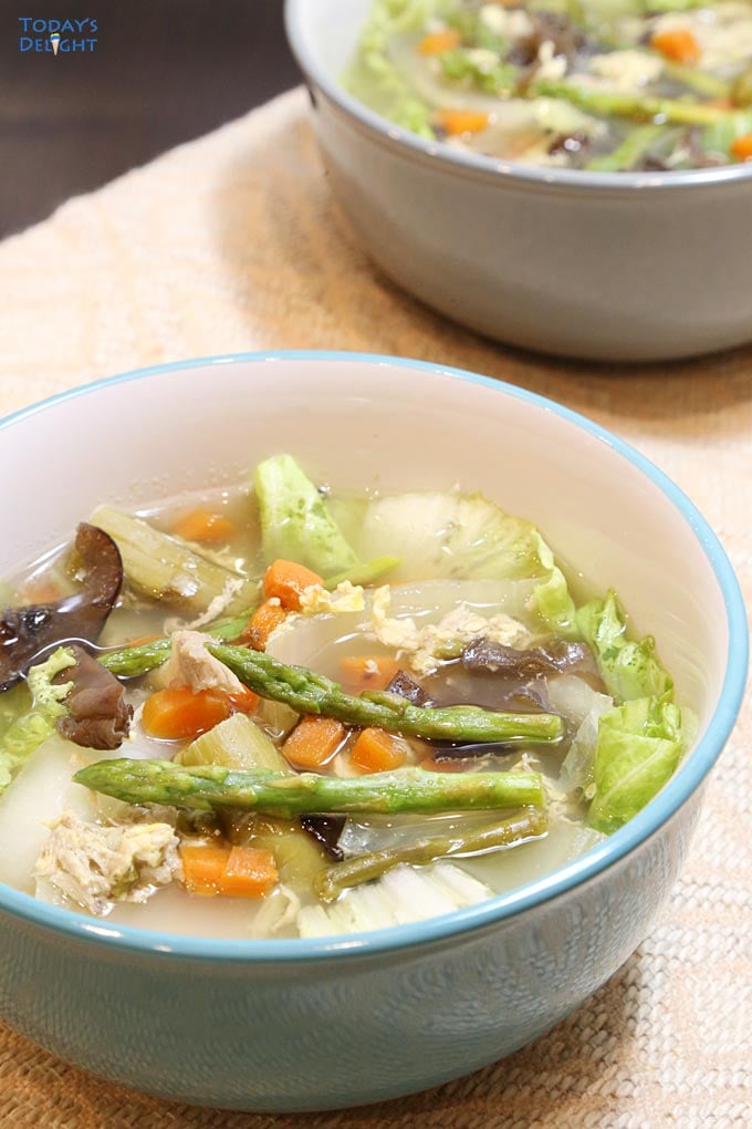 Chicken soup with Asparagus spears in a bowl.