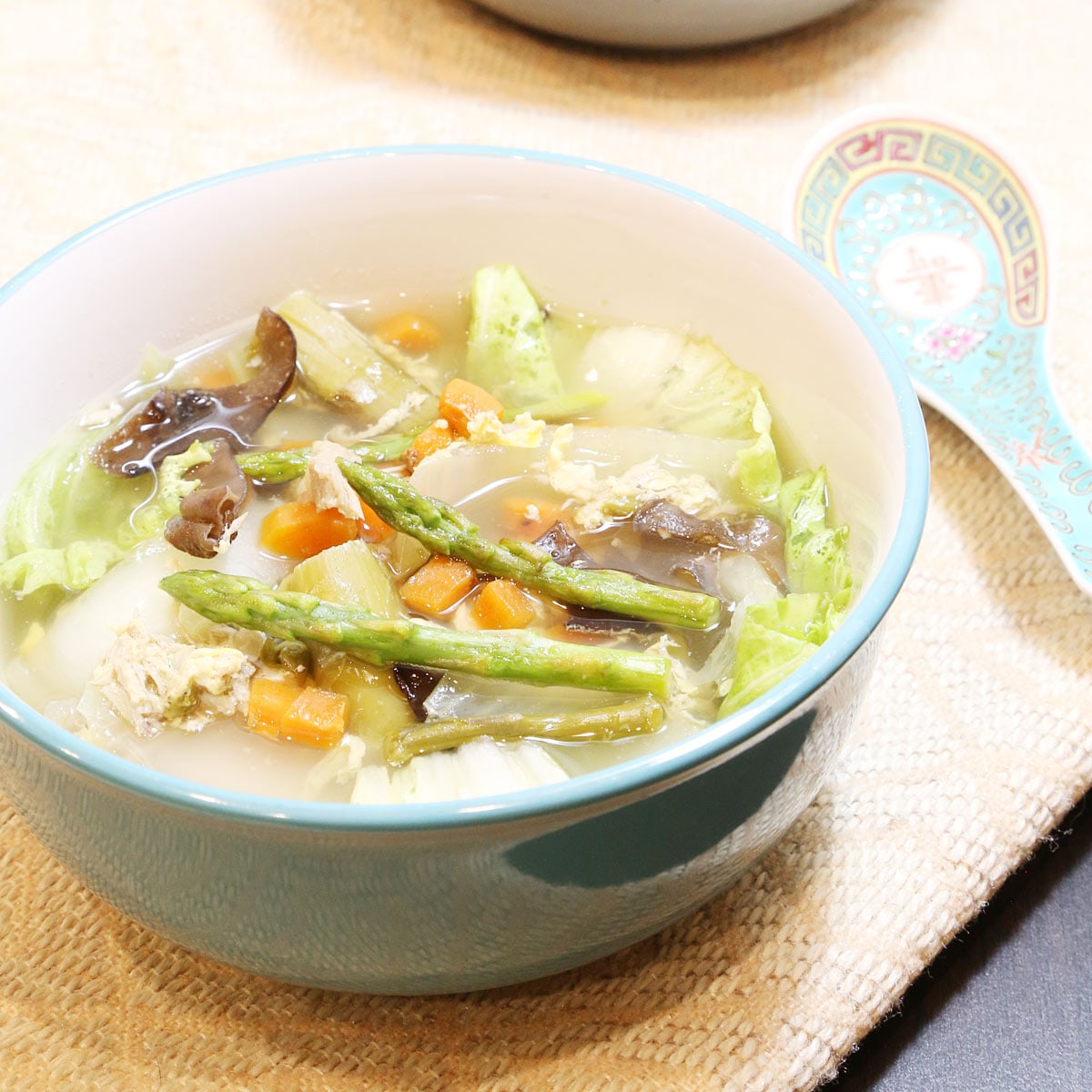 Chicken soup with Asparagus spears in a bowl.