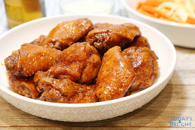 Delicious Crispy Sweet and Spicy Chicken Wings in a bowl with sides.