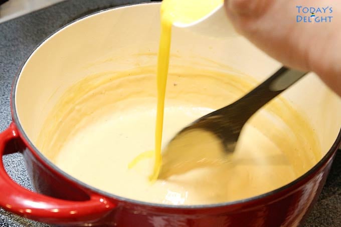 Beaten egg slowly added to bechamel sauce.