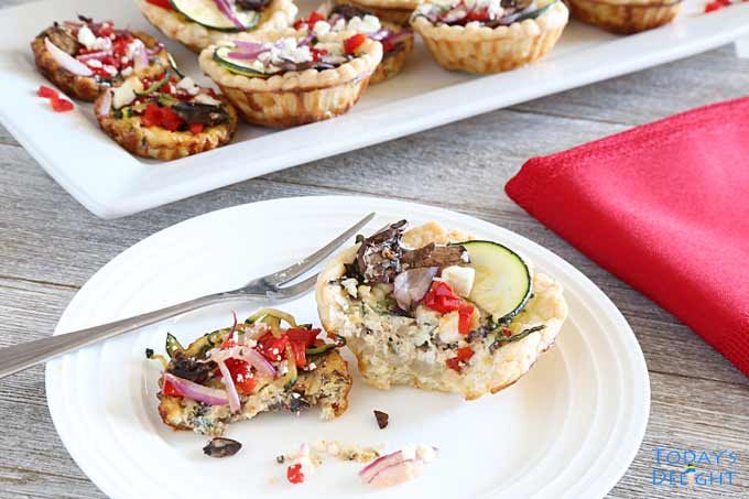 A bite of crust and crustless Mediterranean Mini Quiche.