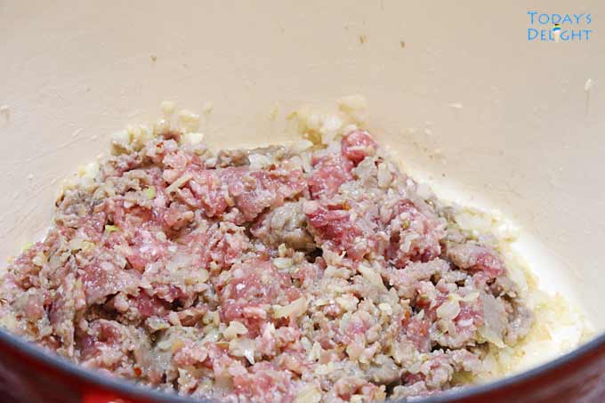 Cooking ground beef and Italian sausage not in casing in a pot.