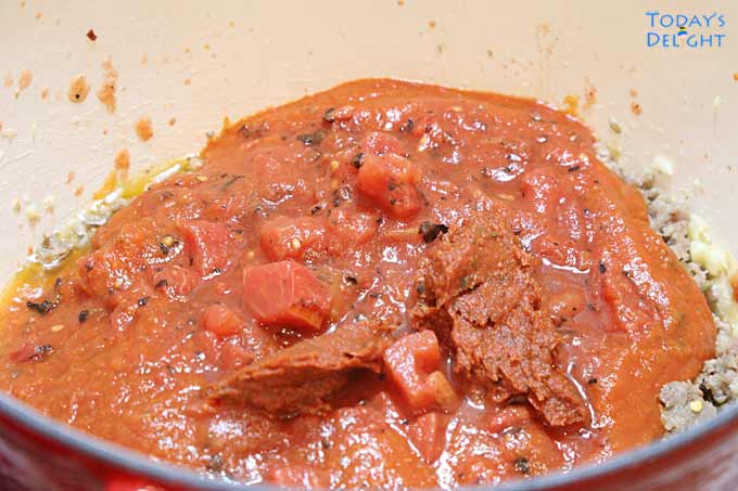In a pot, tomato sauce and diced tomatoes added to the meat mixture.