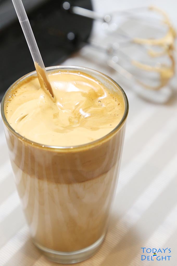 Frothy coffee in glass.