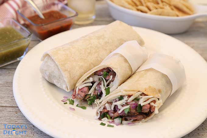 2 beef burrito recipe on plate with chips and red and green salsa.
