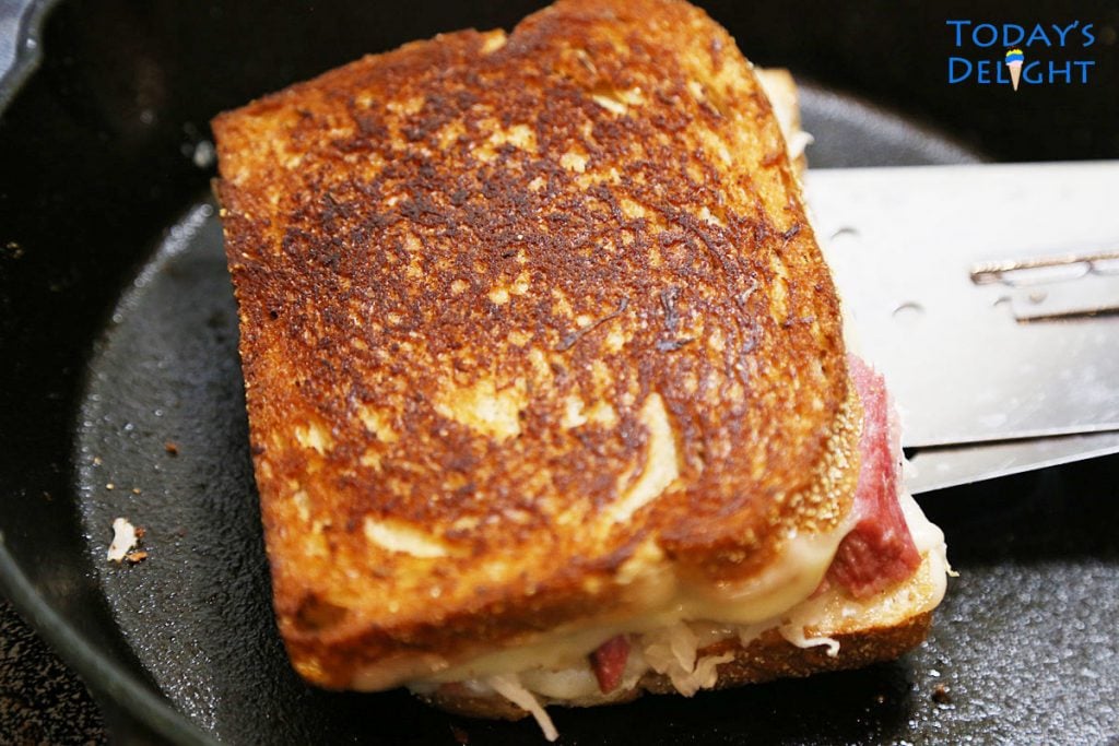 Reuben sandwich toasted in cast iron.