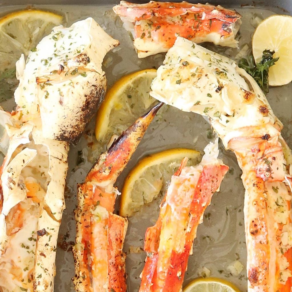 King Crab Legs in Garlic Butter with lemon wedges.
