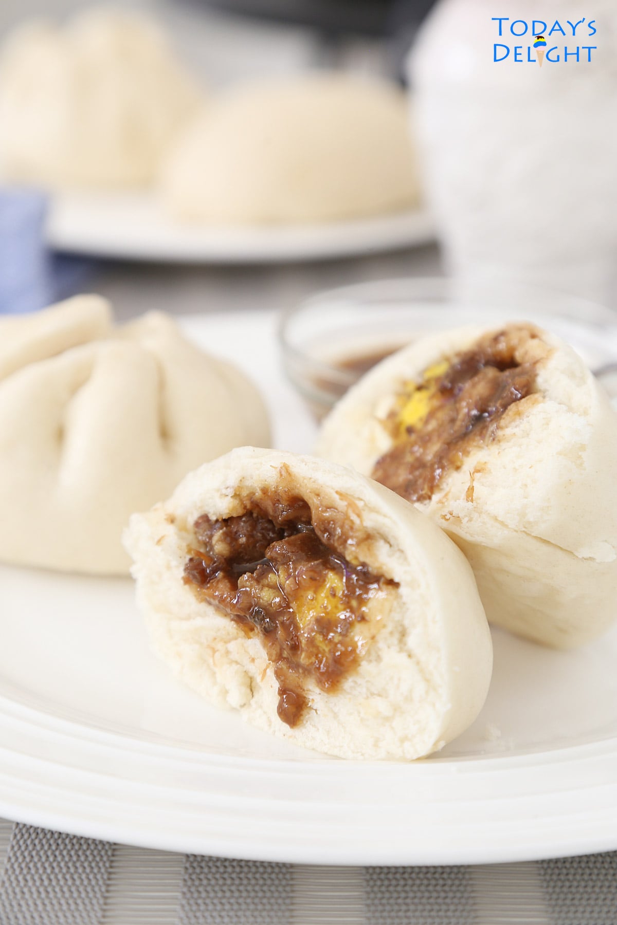 Round and pleated top siopao asado with sauce.