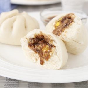 2 Pork siopao asado with egg and sauce.