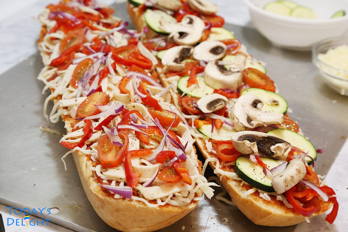 Sliced French bread topped with pizza sauce, cheese and vegetables.