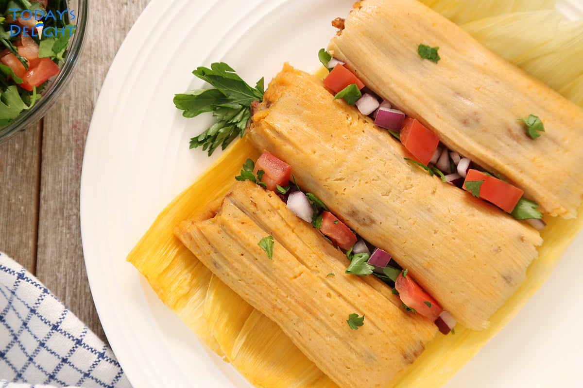 3 unwrapped Mexican tamales with pico de gallo in between.