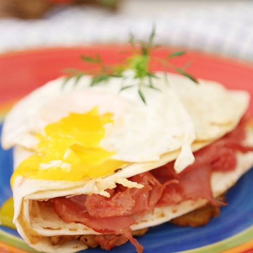 Monte Cristo Sandwich in tortilla wrap with broken over easy egg yolk.