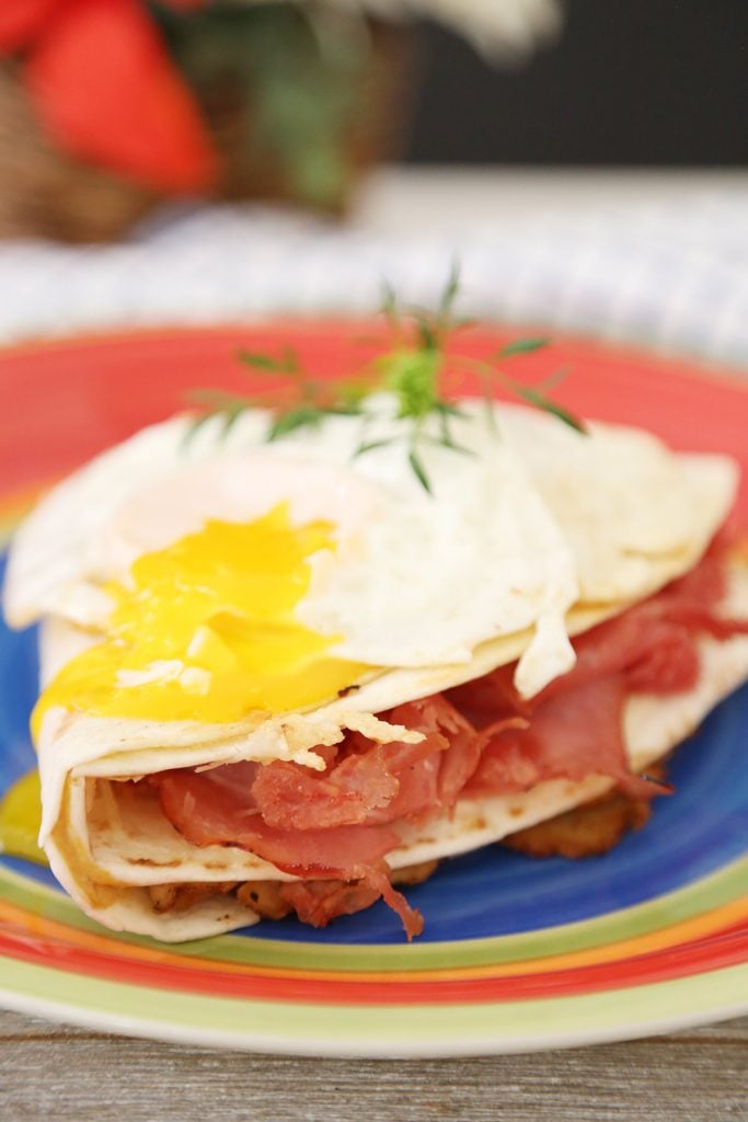 Monte Cristo Sandwich in tortilla wrap with broken over easy egg yolk.