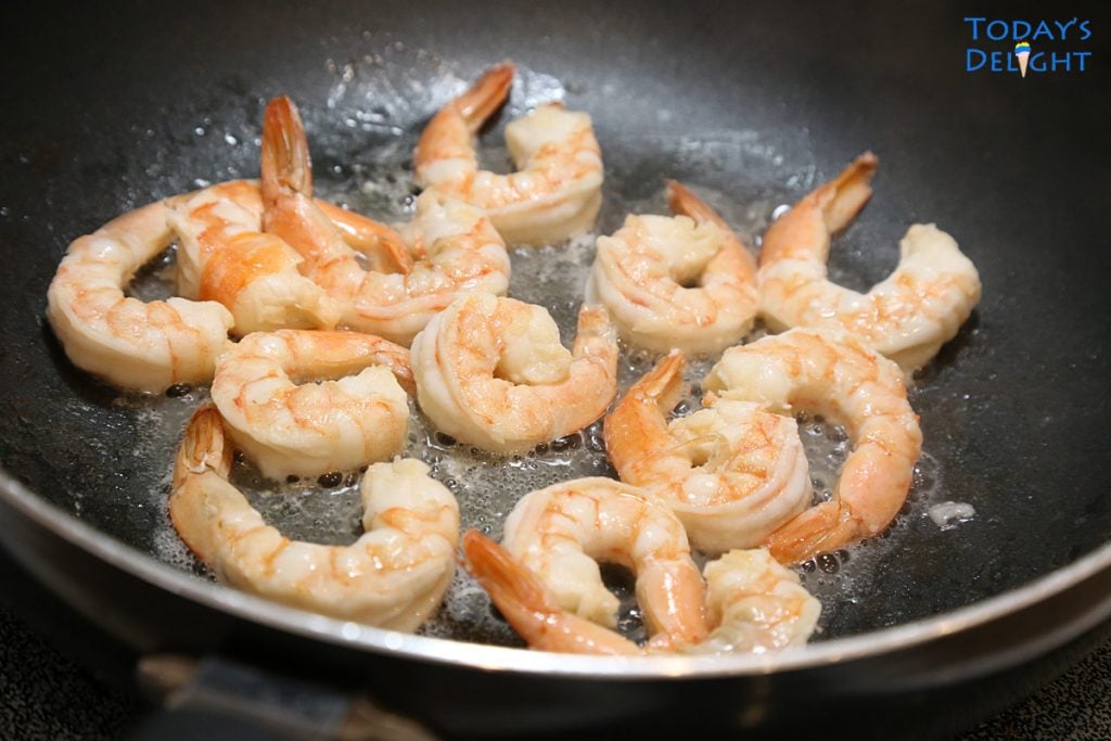 Peeled, deviened, large shrimps stir fried in skillet.