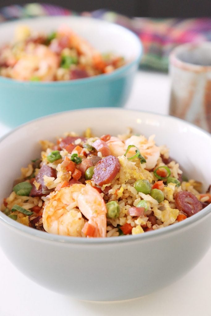 2 servings of shrimp fried rice with Chinese sausage, ham, eggs and vegetables and tea drink.
