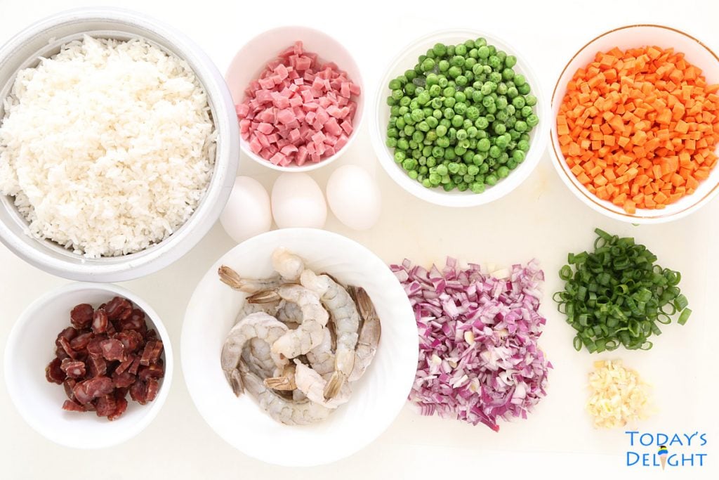 Shrimp fried rices ingredients are white rice, peeled and deveined shrimp, sliced Chinese sausage, diced ham, green peas, diced carrots, whole eggs, chopped red onion and green onion.