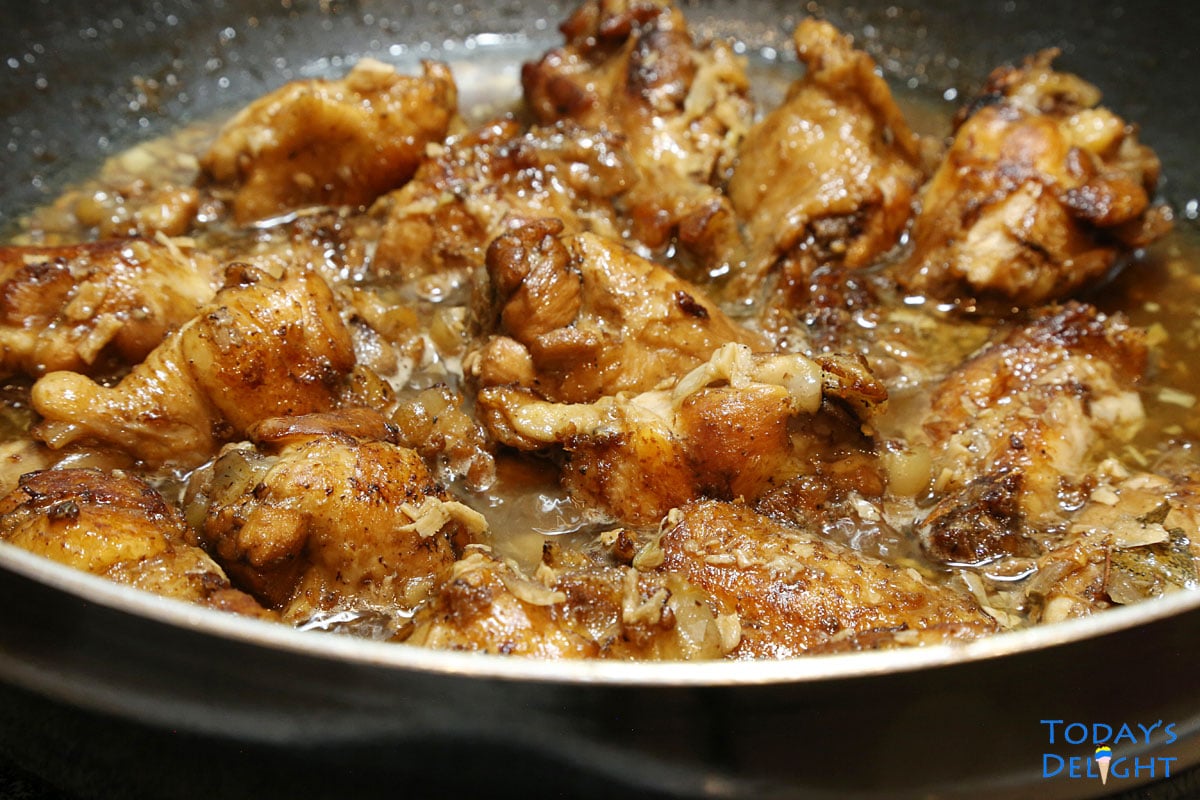 Cooked Filipino chicken wings adobo with sauce in skillet.