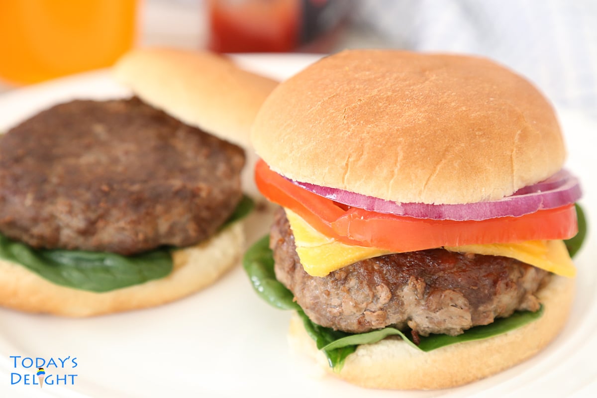 One burger sandwich with toppings and the other one with burger and spinach.