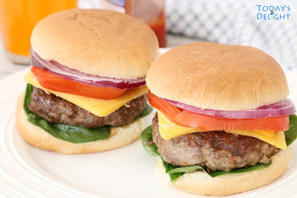 2 moist burger sandwiches with red onion, tomato, spinach and cheese.
