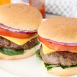 2 moist burger sandwiches with red onion, tomato, spinach and cheese.