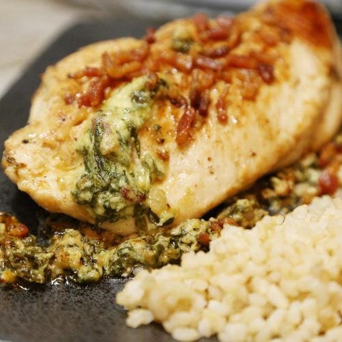 Cheesy stuffed chicken garnish with bacon and side or brown rice.
