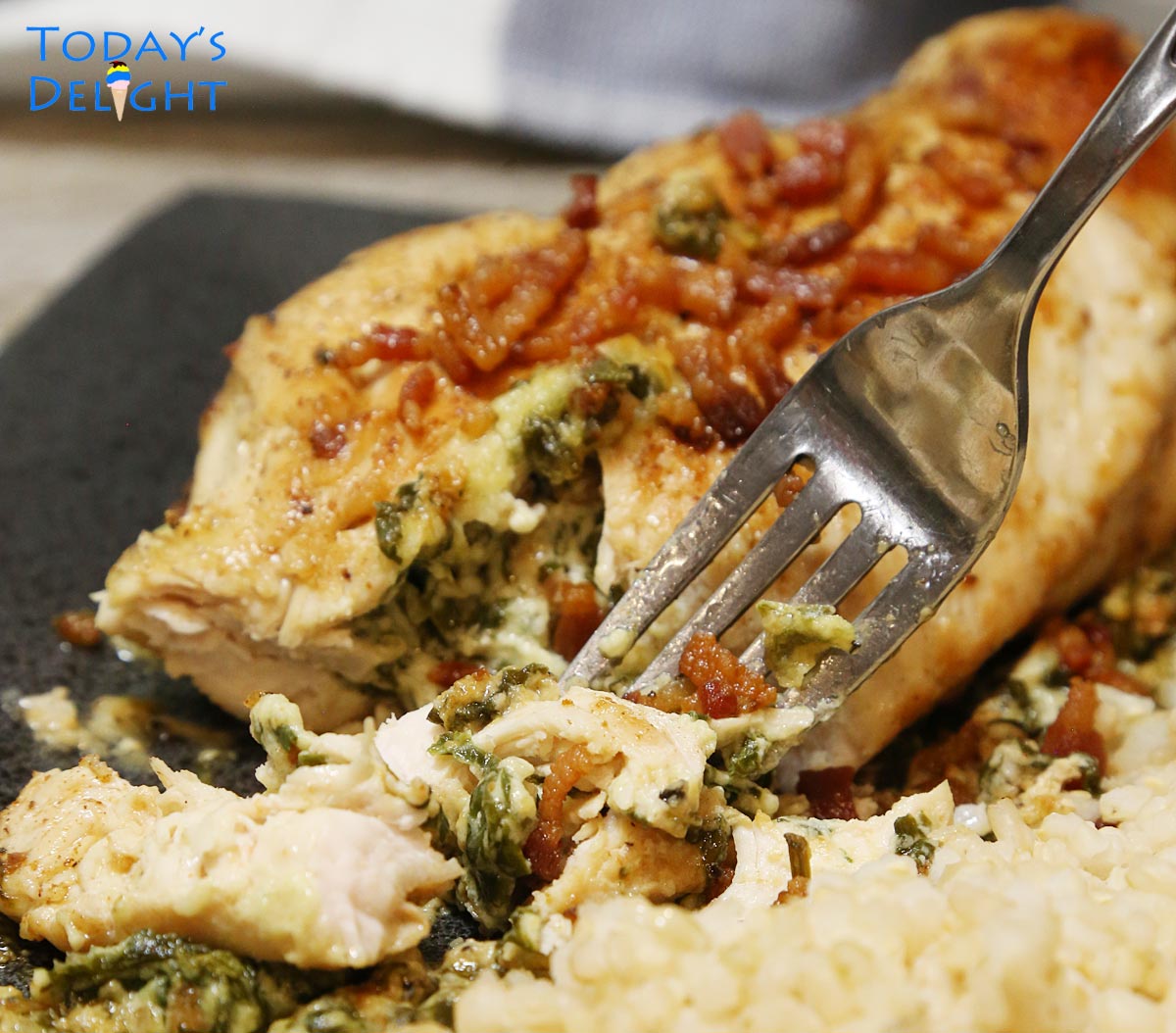 Tender, juicy sliced stuffed chicken with fork.