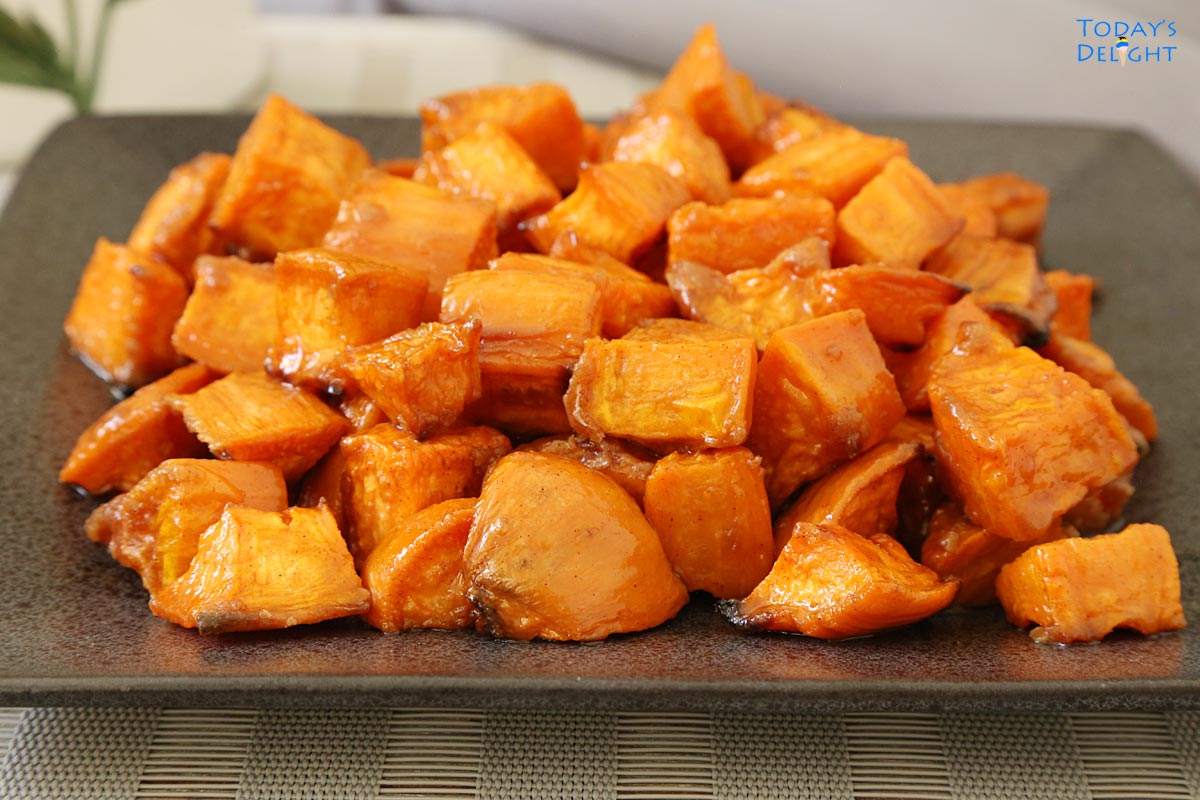 Oven roasted sweet potatoes with glaze on a gray plate.