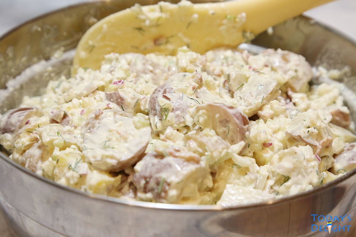 Dill potato salad ingredients mixed together in a big bowl.