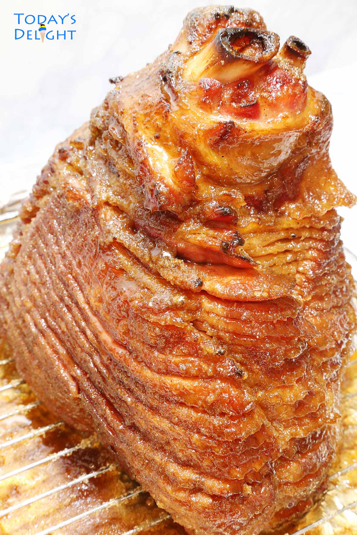 A 9 pound cooked glazed ham on a roasting pan.
