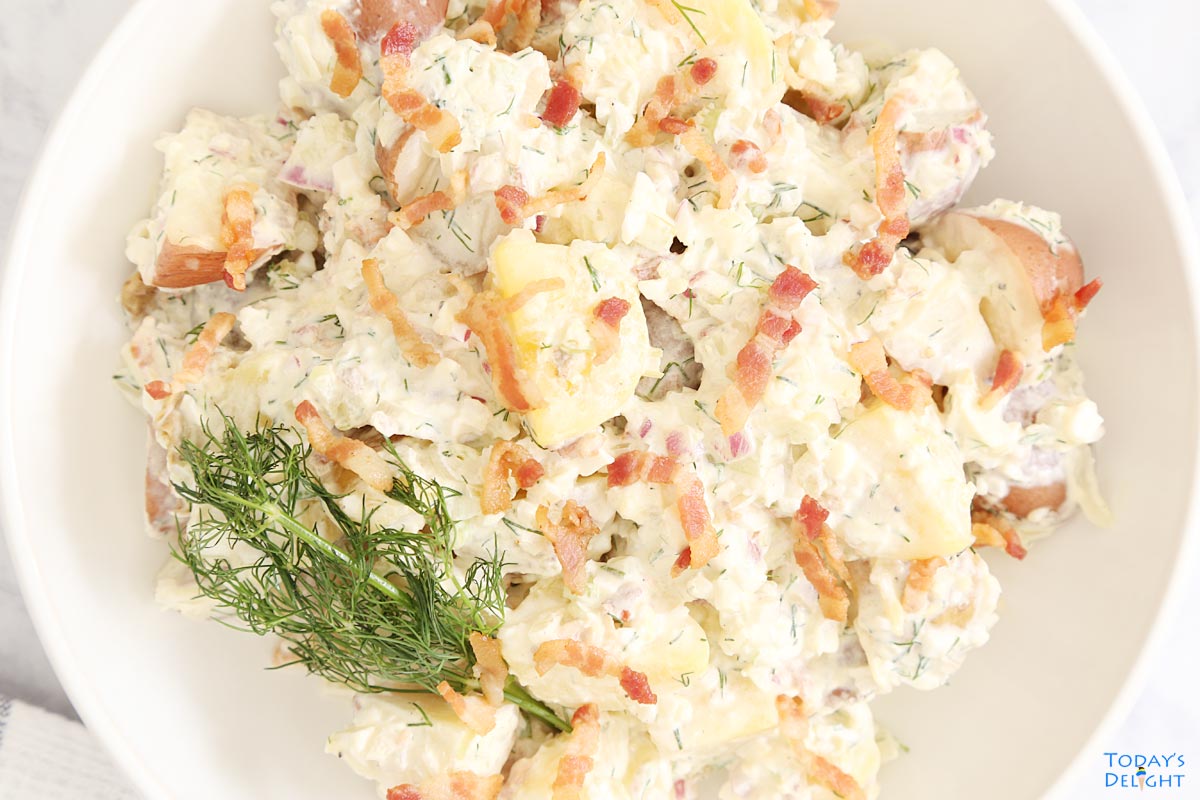 Sour cream dill potato salad with bacon in a bowl.