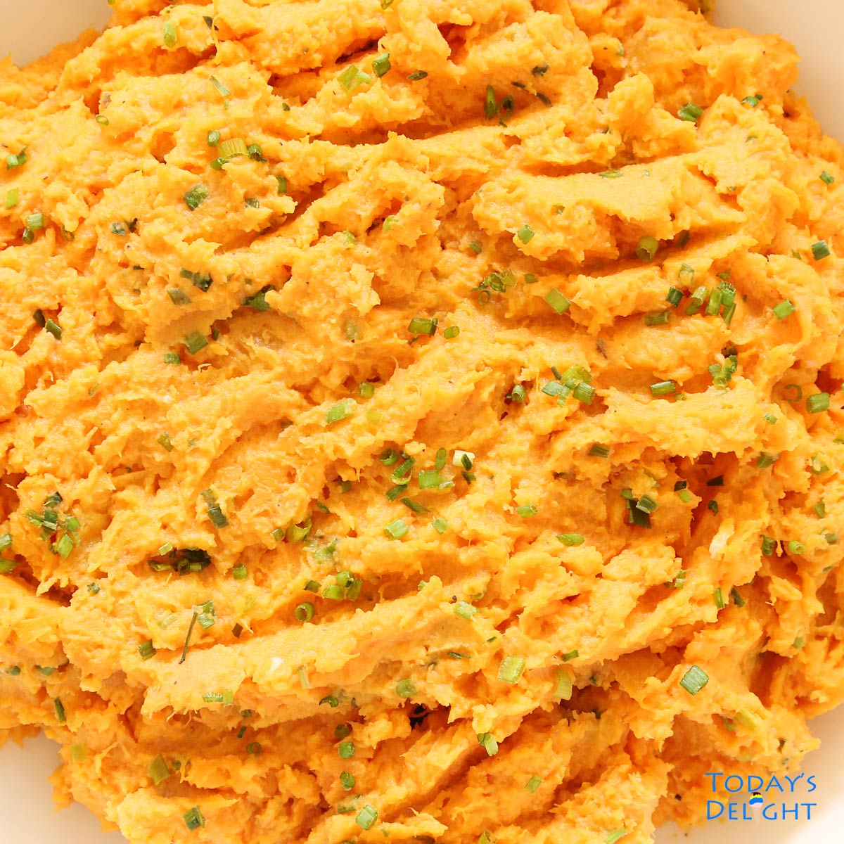 Close up of mashed sweet potatoes with chives.