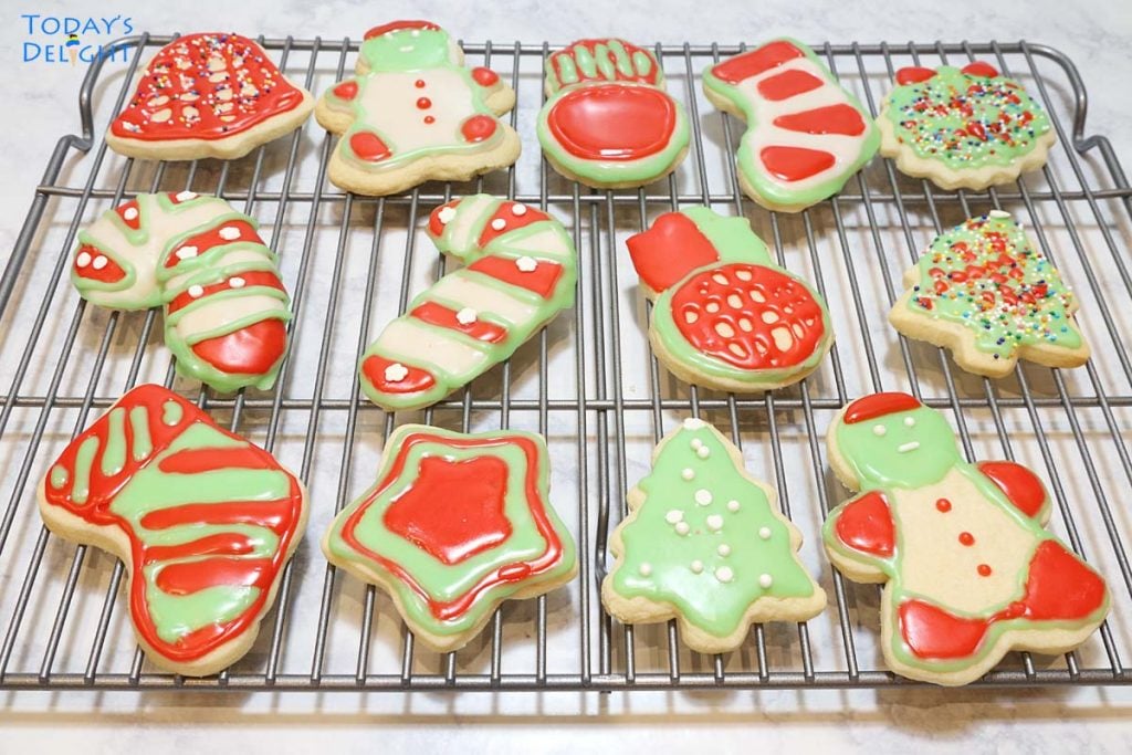 13 different cut-out Christmas cookies on a rack.