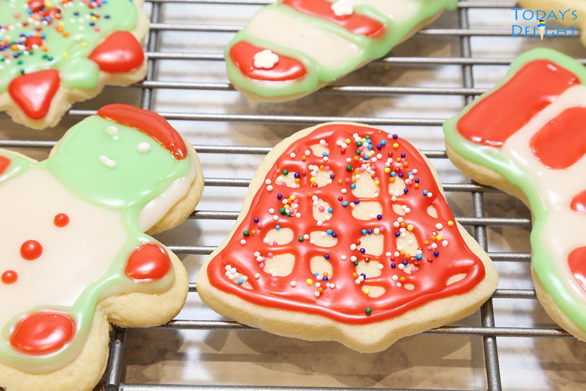Different cut-out decorated sugar cookies on a rack.