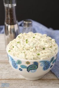 Mashed potatoes in a bowl with salt and pepper in the background.